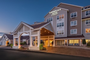 A Towneplace Suites hotel with a covered entrance, multiple floors, and a well-lit facade.