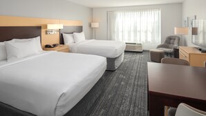 A hotel room with two beds, a desk, a chair, a TV, and a window with curtains. - TownePlace Suites by Marriott Wareham Buzzards Bay (Wareham)