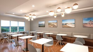 A modern dining area with round tables, grey chairs, and a sofa. - TownePlace Suites by Marriott Wareham Buzzards Bay (Wareham)