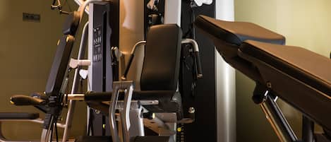 Een rij stilstaande fitnessapparaten in een sportschool.