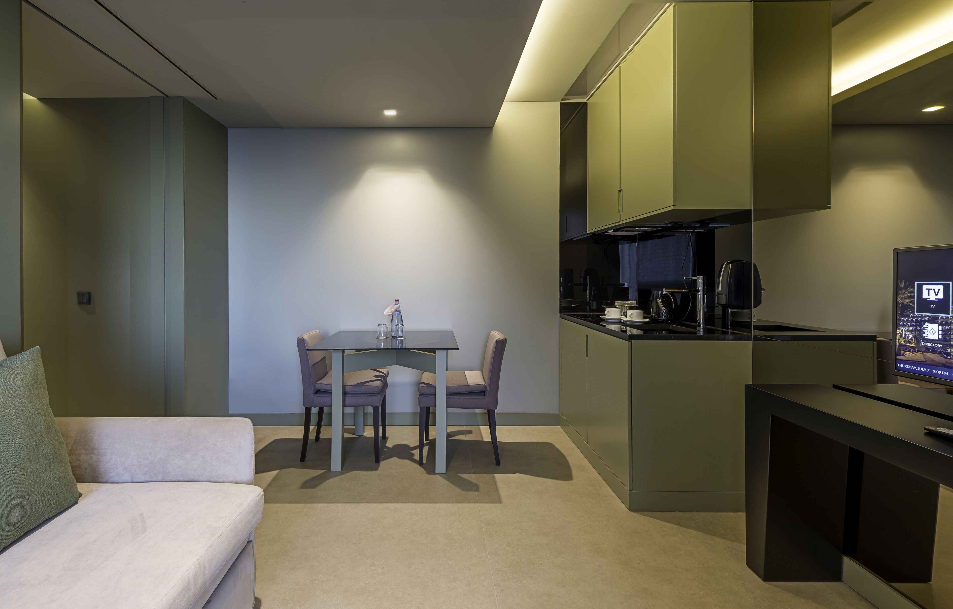 Un espacio habitable compacto con kitchenette, comedor y sofá.
