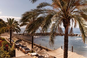 Una playa cerca, sillas reclinables de playa, sombrillas