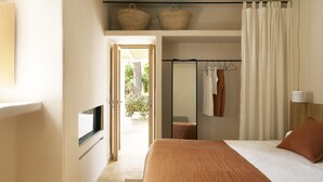 A bedroom with a bed, a TV, a wardrobe, a mirror, and a window. - Casbah Formentera Hotel & Restaurant (Formentera)