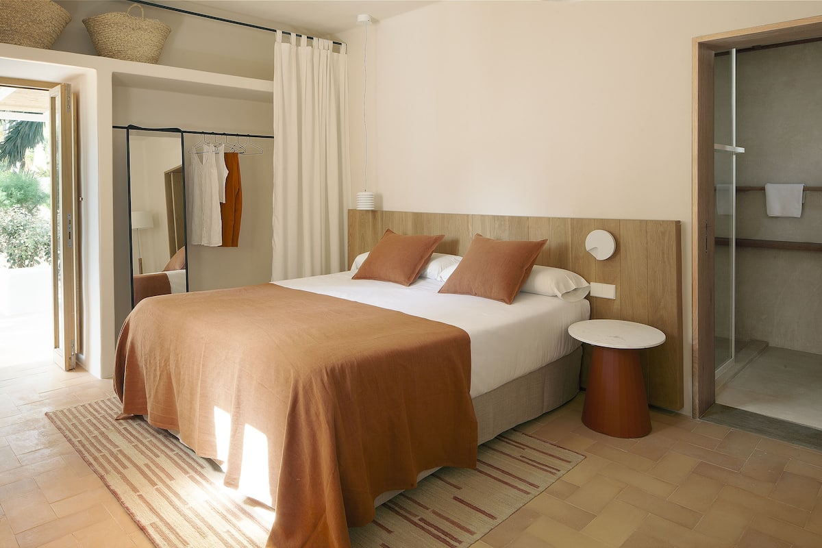 Quarto moderno com cama grande, mesas de cabeceira e closet espaçoso.