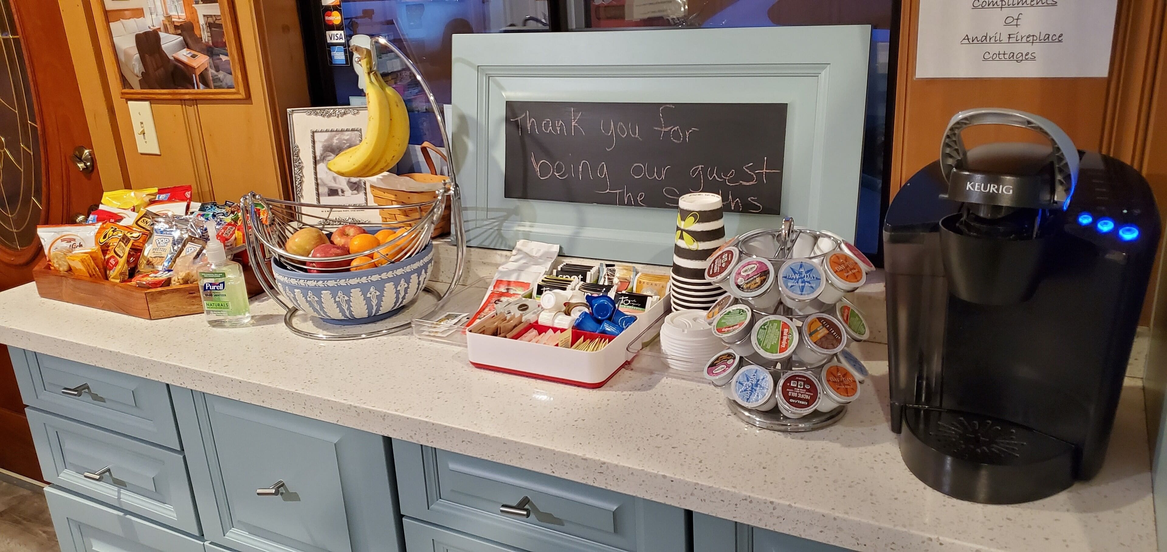 A breakfast buffet setup with various food items, a Keurig coffee machine, and a chalkboard sign expressing gratitude to guests.