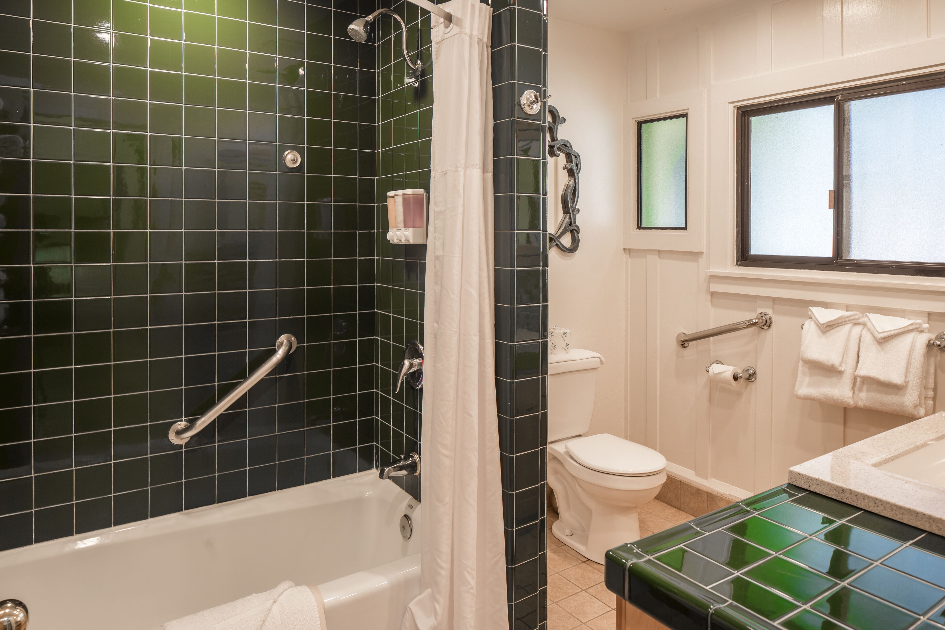 Un baño con bañera, inodoro y zona de ducha.