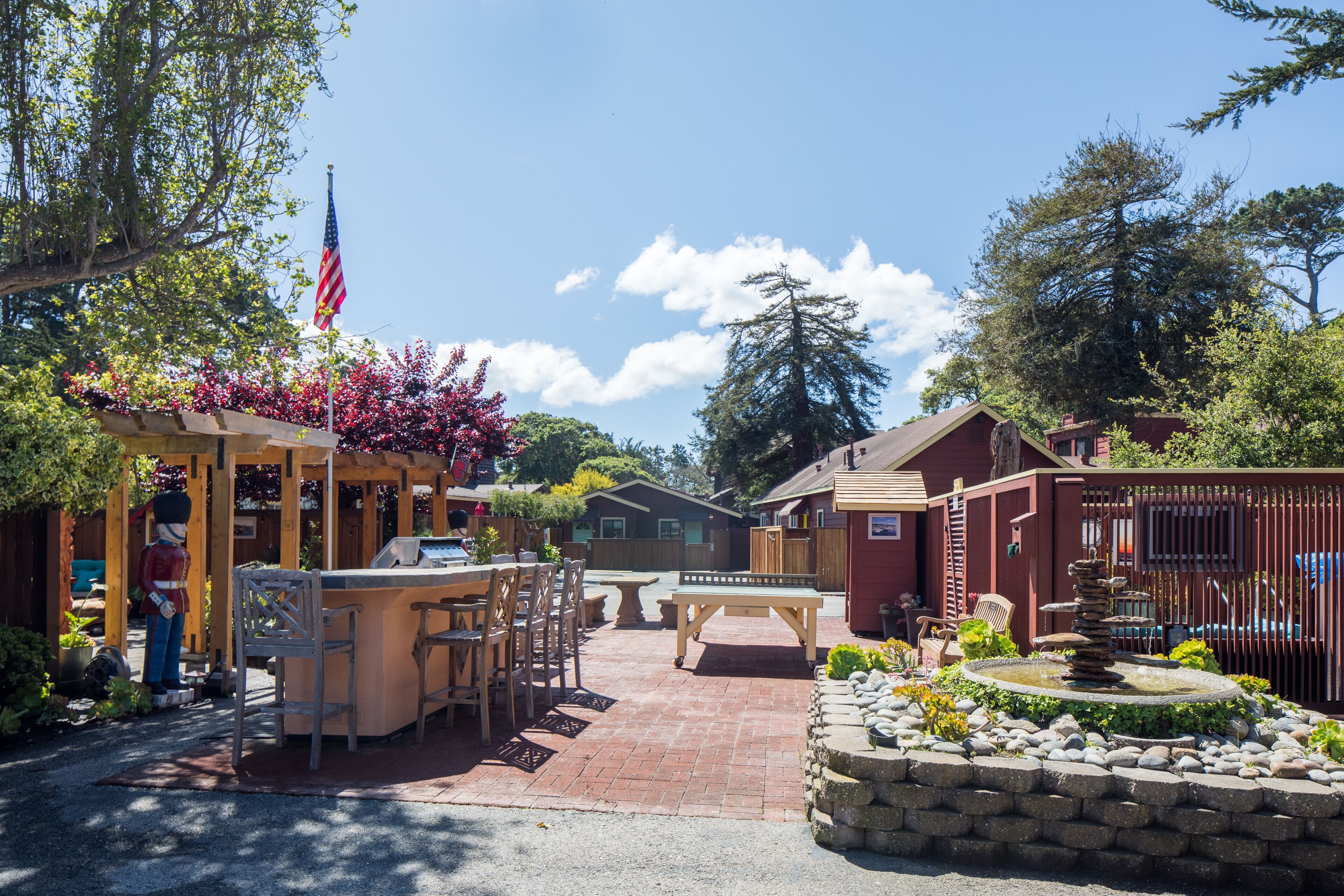 A patio area with outdoor furniture, a stone fountain, and a flagpole.