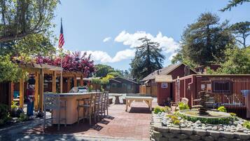 A patio area with outdoor furniture, a stone fountain, and a flagpole.