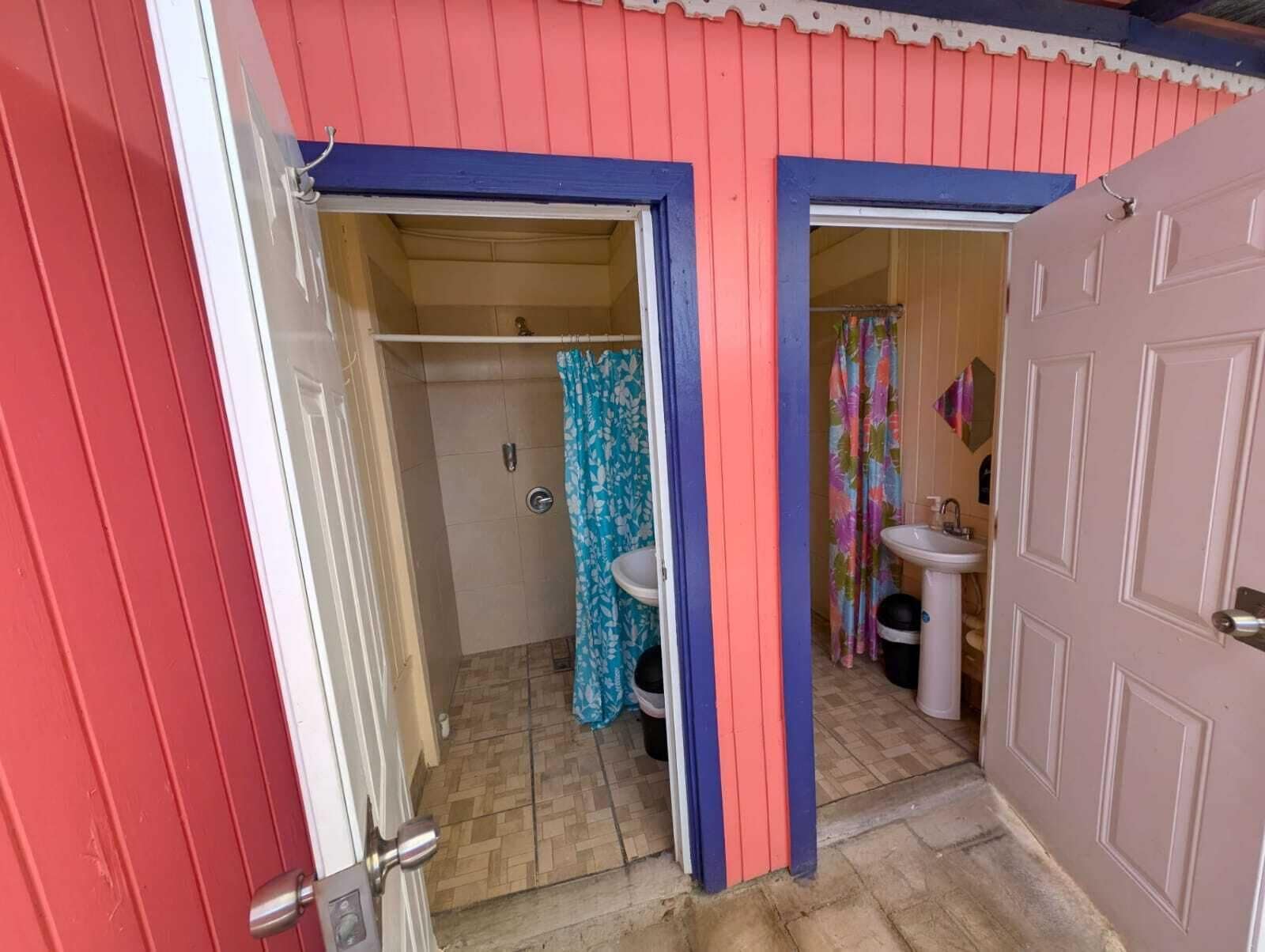 Een badkamer met douche, toilet en wastafel.