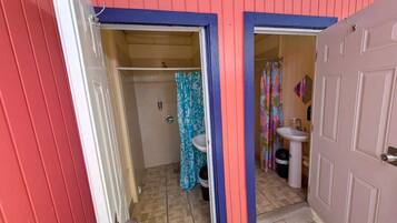 Een badkamer met douche, toilet en wastafel.