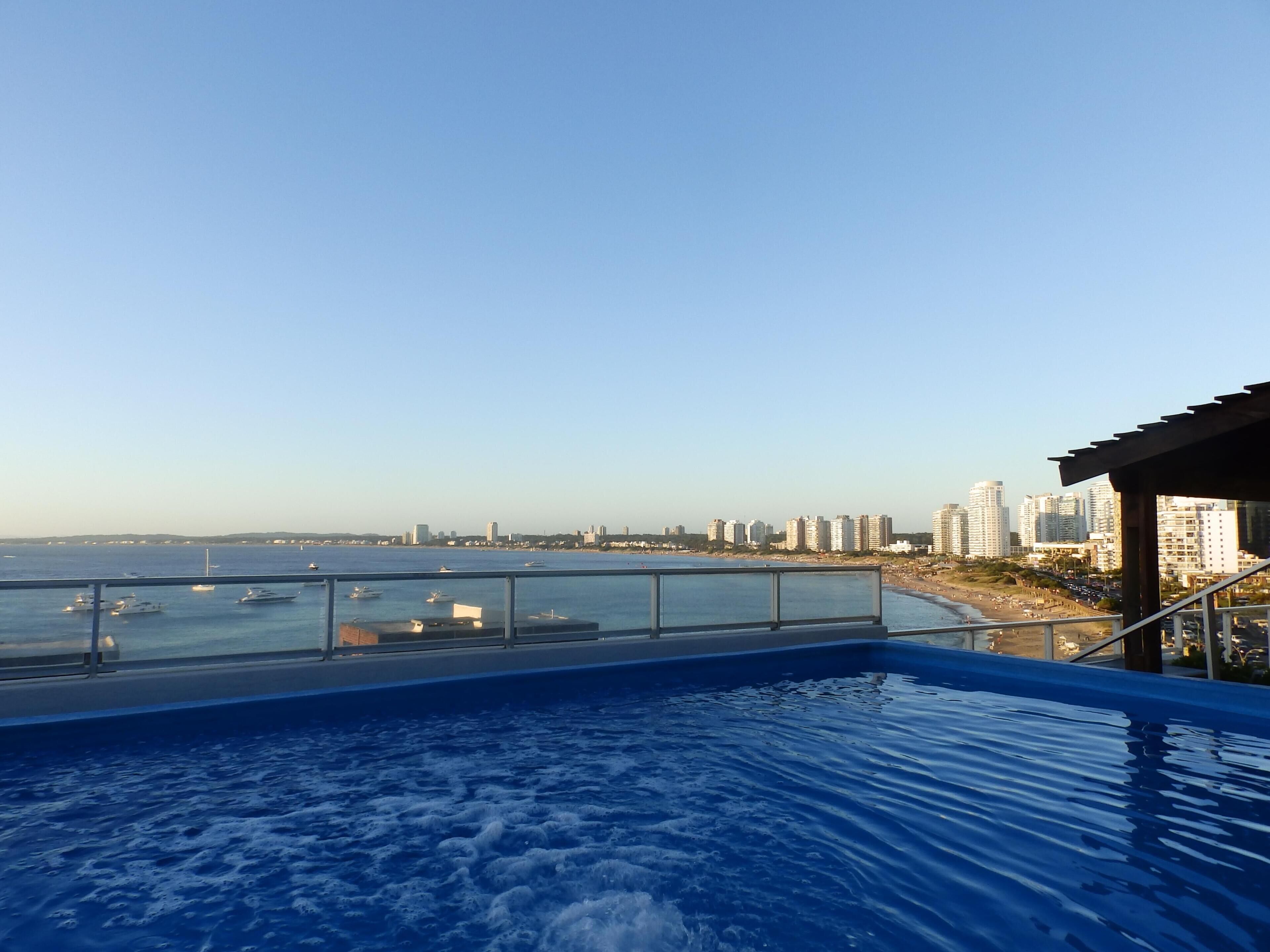Una piscina con vistas a un horizonte urbano y una playa.