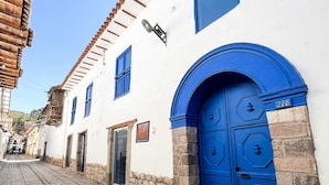 A narrow cobblestone street with white buildings and blue doors. - Quinta San Blas by Ananay Hotels (Cusco)