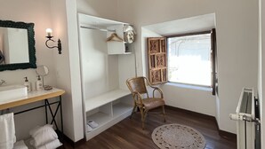 A modern bathroom with a wooden floor, a sink with a mirror, a chair, and a window with a view. - Quinta San Blas by Ananay Hotels (Cusco)