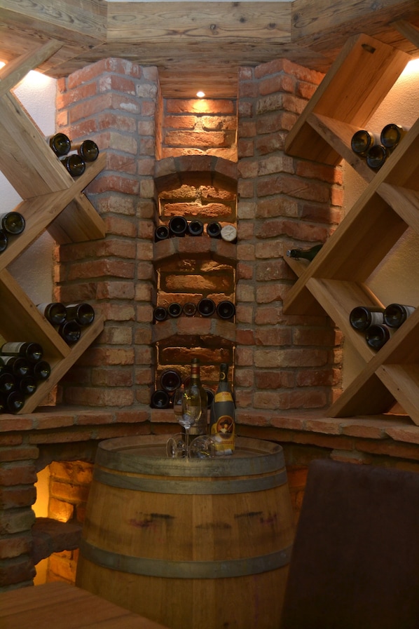 Una bodega con estanterías de madera para vinos y un barril.
