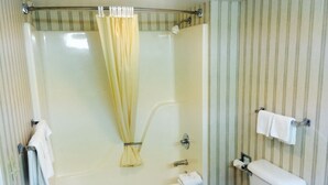 Un baño con bañera, inodoro y cortina de ducha.