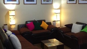 Un saló amb un sofà marró, una taula de centre i quadres amb marc a la paret.