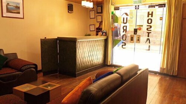 Un vestíbul d'hotel amb una recepció, un sofà i una taula de cafè.