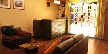 Un vestíbulo de hotel con una recepción, un sofá y una mesa de centro.