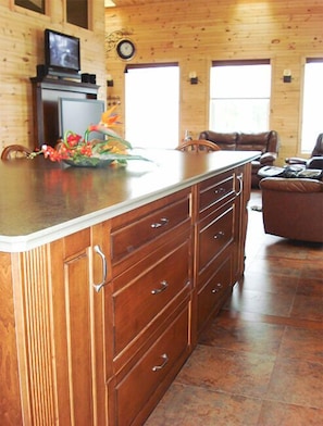Una cocina con armarios de madera, una encimera y un reloj en la pared.