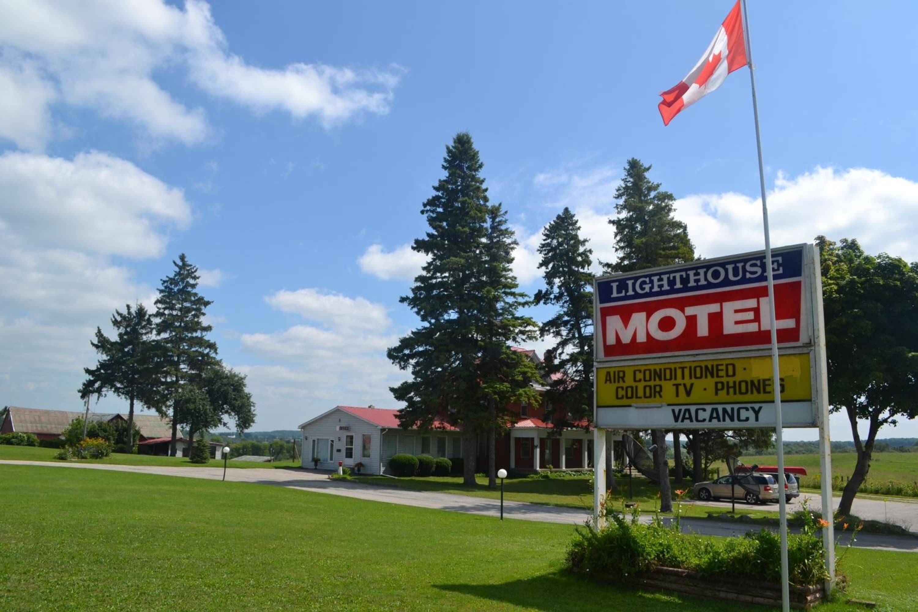 A motel sign with amenities including air conditioning, color TV, and phone.