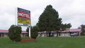 A motel sign with amenities including air conditioning, color TV, and phones, and a vacant status.