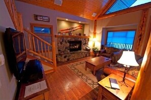 Cozy living room with a fireplace, comfortable seating area, and a staircase leading to an upper level.