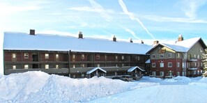 A hotel with multiple floors, a snow-covered roof, and a sign indicating it is a Chateau.