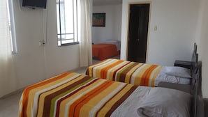 A room with two beds, each with striped bedding, a television on the wall, and a door leading to another room. - Hotel Vermon (Armenia)