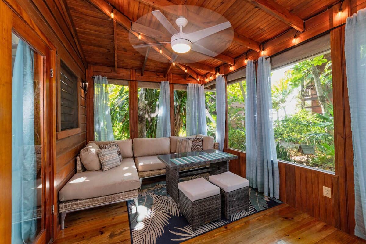 Una cabaña de madera acogedora con un sofá, otomanas y una mesa.