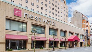 Un hotel con un letrero llamativo, varias ventanas y toldos rojos.