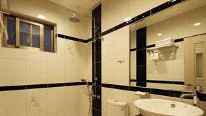 Et badeværelse med toilet, håndvask og bruser.