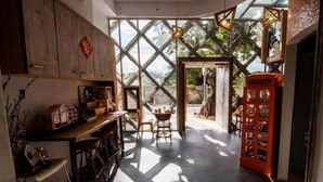 Una cocina moderna con mostrador de madera, taburetes y un teléfono rojo.