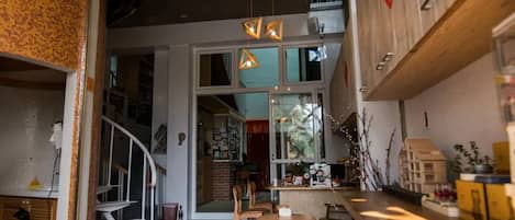 A modern interior with a staircase, wooden furniture, and pendant lighting.