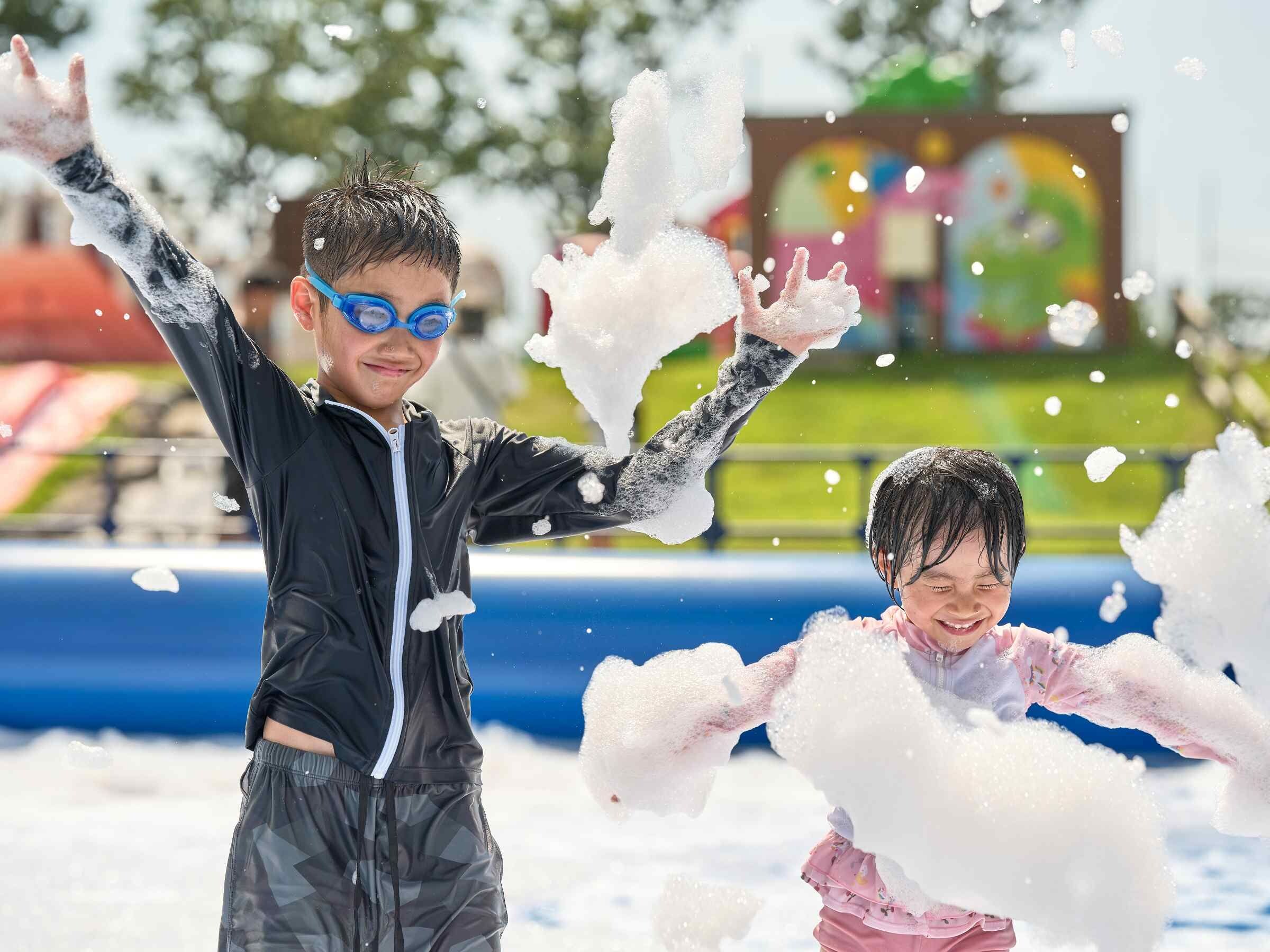 Two children playing with snow in an outdoor setting.