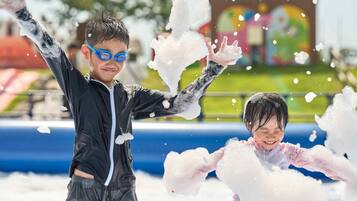 Two children playing with snow in an outdoor setting.