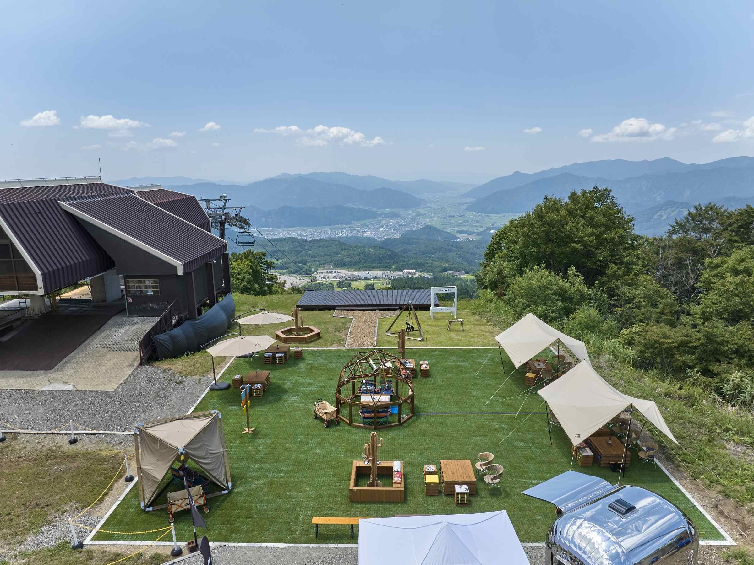 A campsite with tents, tables, and a view of the mountains.