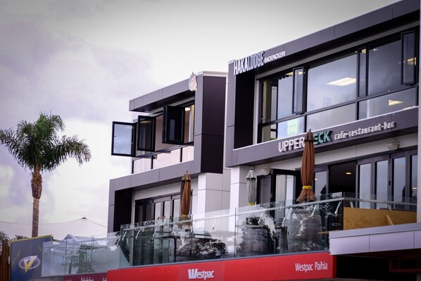 Un edificio moderno con un letrero que dice 'Haka Lodge Backpackers' y 'UPPERBACK, café-restaurante-bar'.
