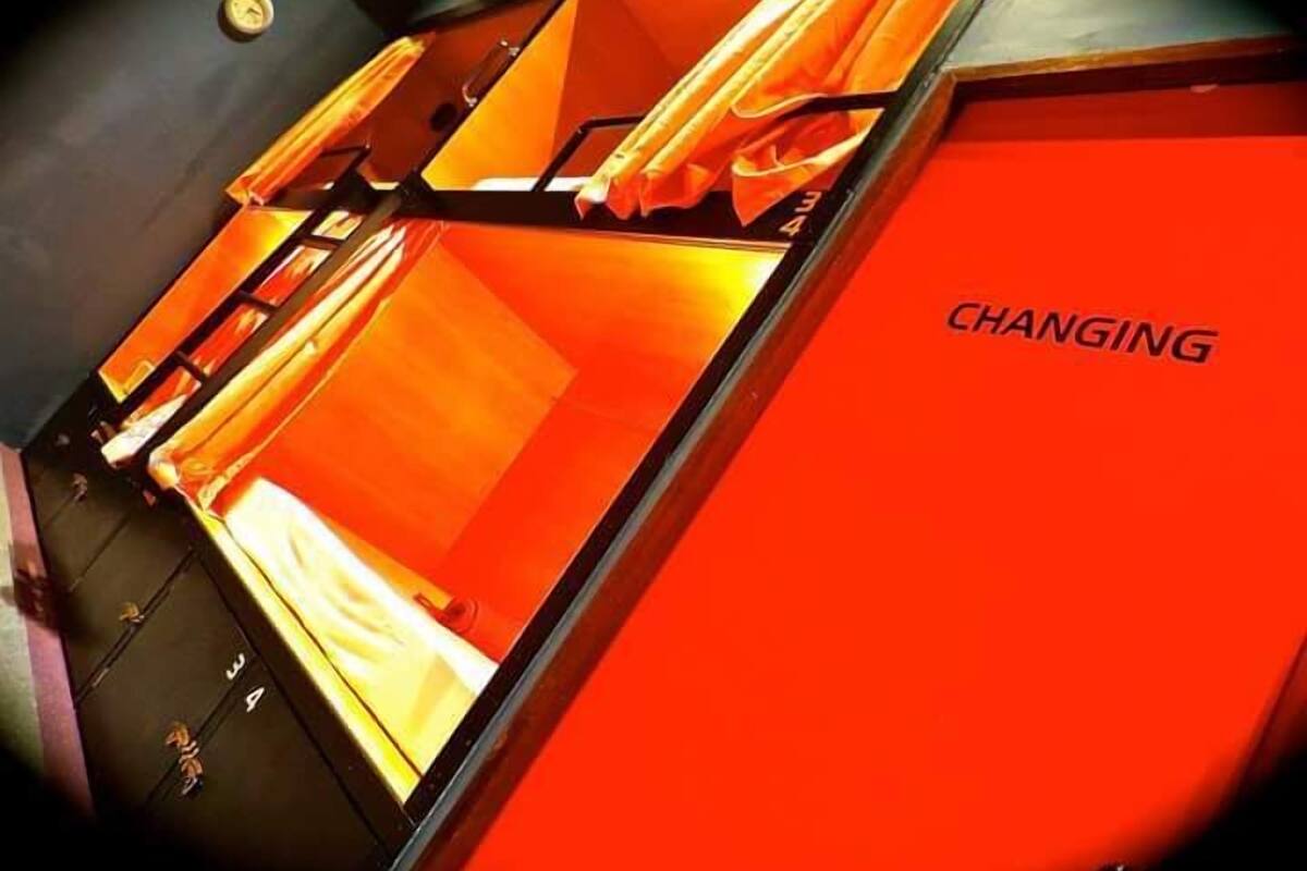 Une pièce avec un mur rouge et une grande fenêtre. Le mot « CHANGING » est visible sur le mur.