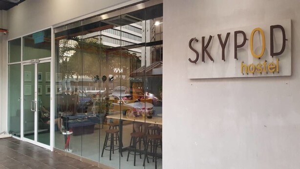 A hostel named 'SKYPOD' with a modern interior visible through the glass doors. - SKYPOD Hostel (Kota Kinabalu)