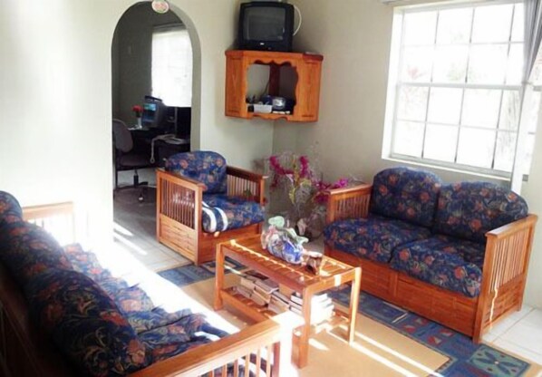 A living room with two sofas, a coffee table, and a television on a shelf.
