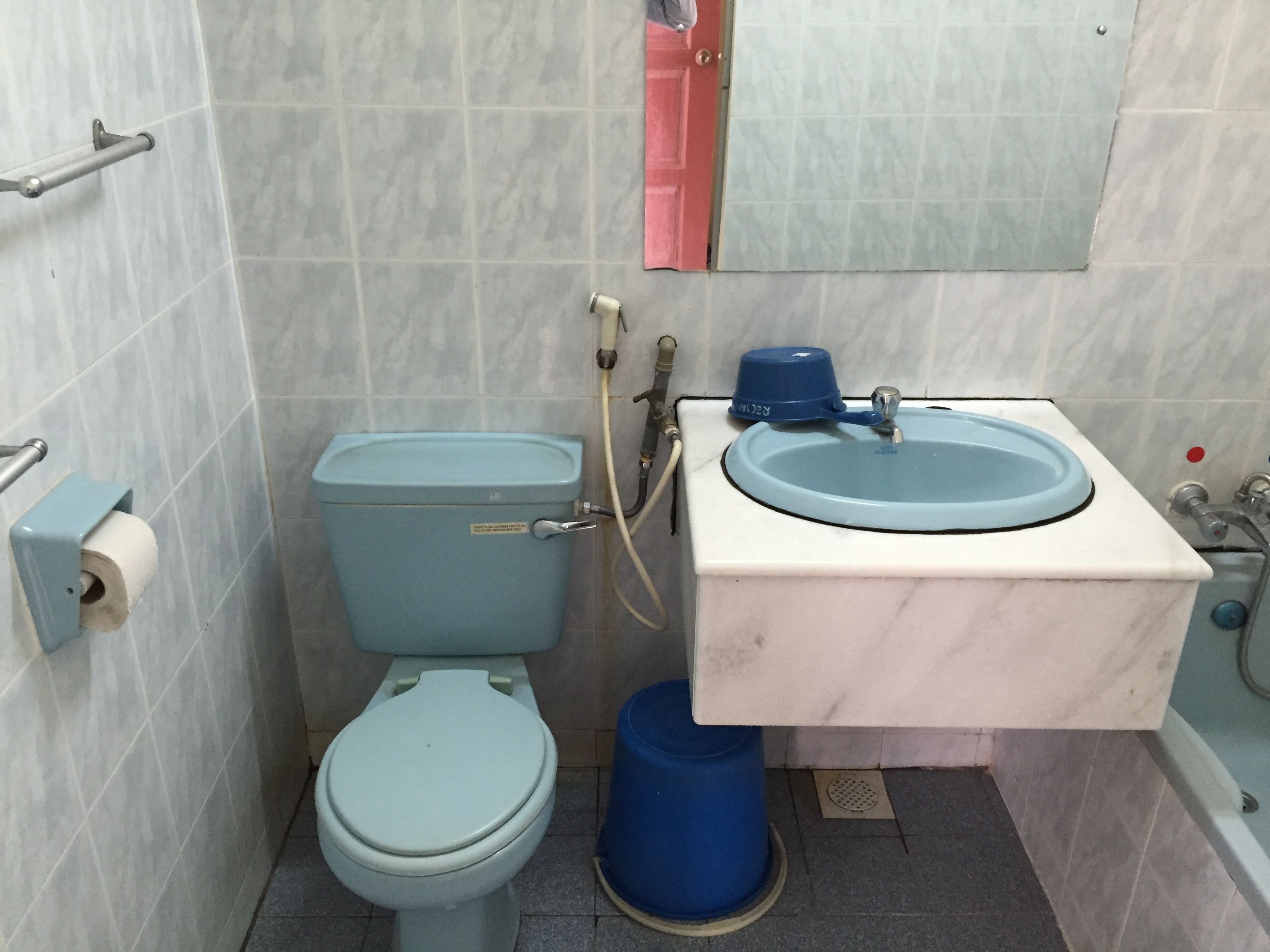 Une petite salle de bain avec des toilettes, un lavabo et un miroir.