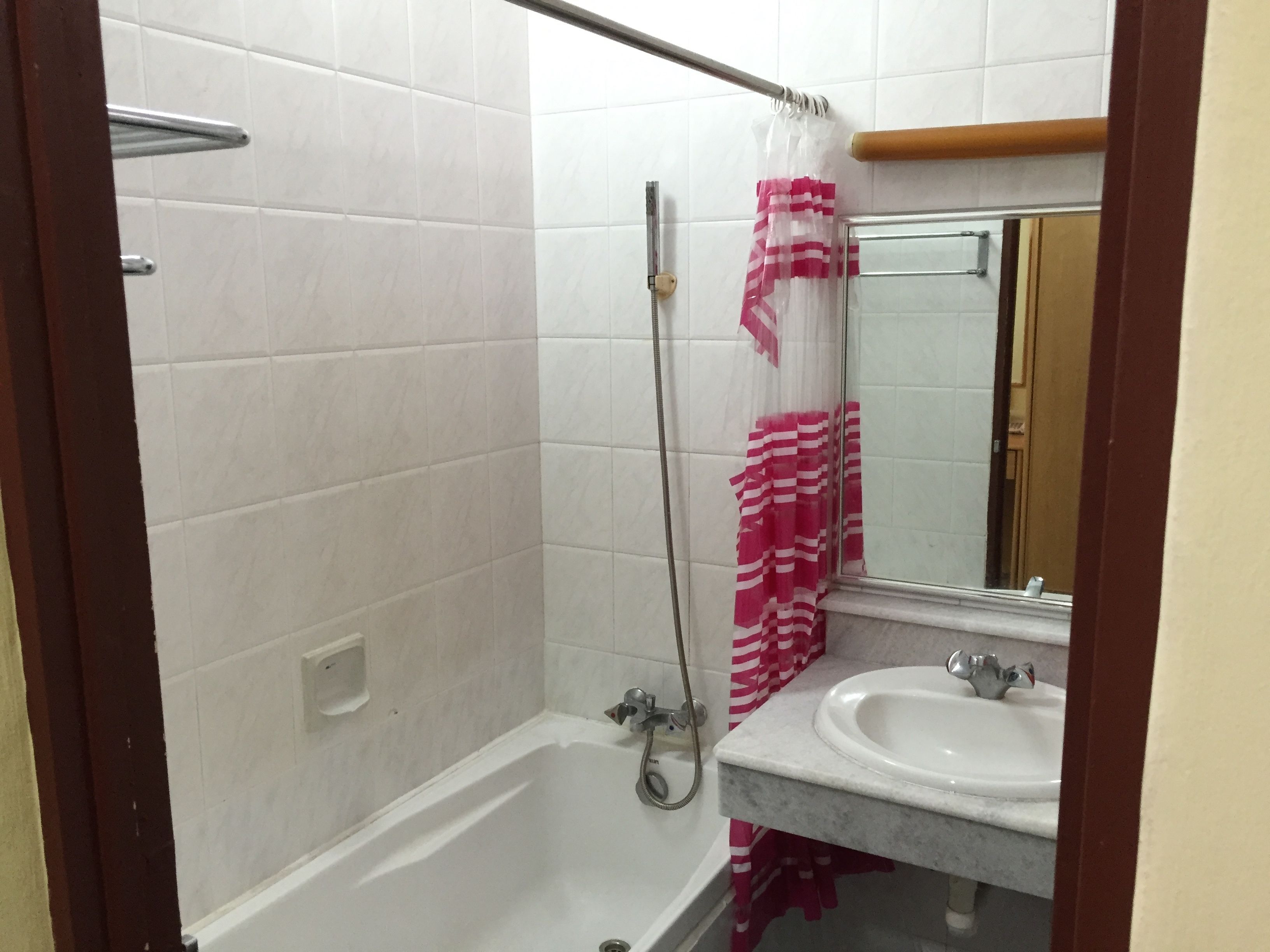 Ein Badezimmer mit einer weißen Badewanne, einer Dusche, einem Waschbecken und einem Spiegel.