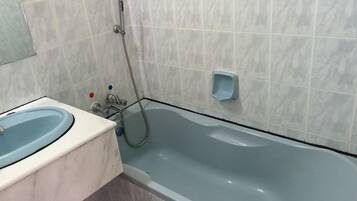 Un baño con bañera, lavamanos y ducha.