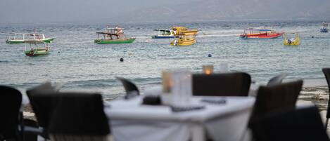 A seaside restaurant with outdoor seating overlooking the sea.