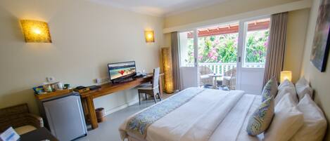 A hotel room with a bed, desk, and a small refrigerator.