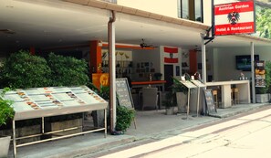 An Austrian Garden Hotel & Restaurant with outdoor seating and a menu board.
