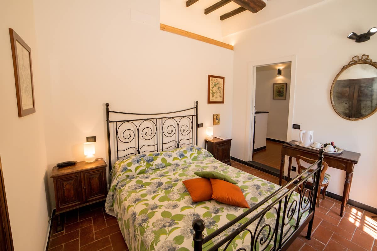 Une chambre à coucher comprenant un lit, des tables de chevet, un miroir et une porte donnant sur une autre pièce.