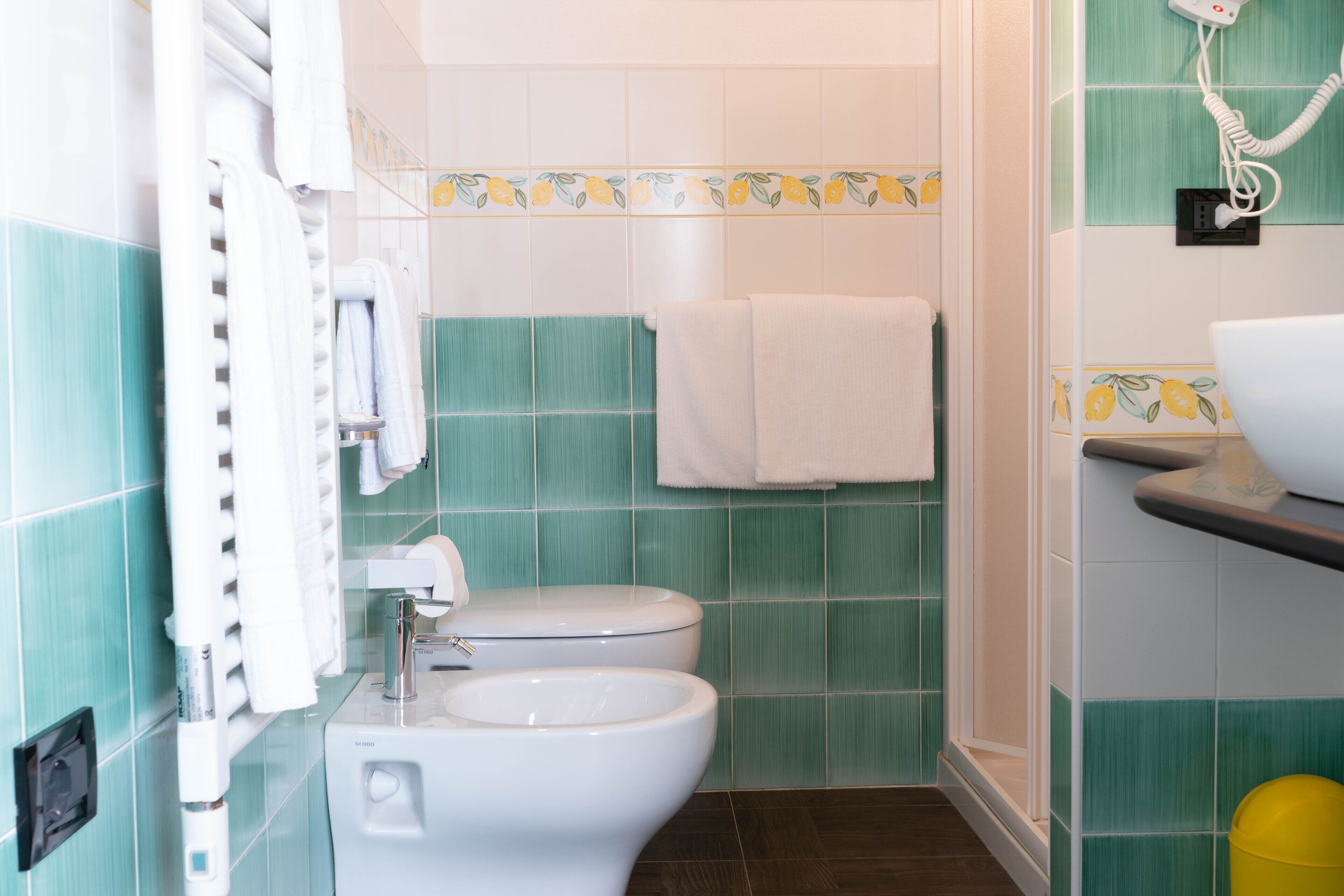 Un baño con inodoro, lavamanos y un perchero para toallas.