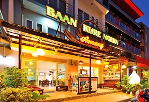Une entrée d’hôtel bien éclairée, avec une enseigne indiquant « BAAN KURE Nongern ».