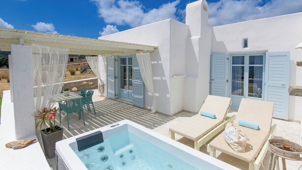 Terraza en la azotea con jacuzzi, sillones de descanso y una mesa con sillas.